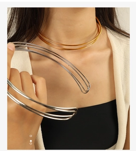 Detail of minimalist gold and silver double-layer C-shaped choker on model