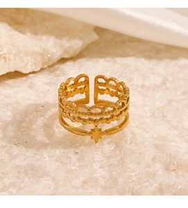Detail of a gold multilayer lace ring with star pendant on a white crystal stone