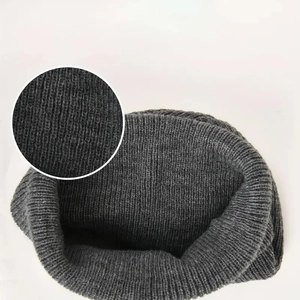 Detail view of the ribbed knit pattern and interior lining of the dark gray beanie