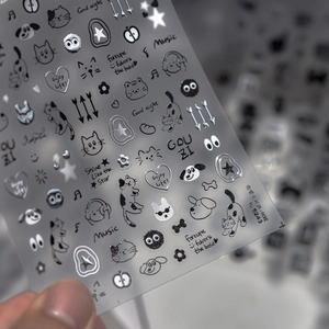 Macro view of embossed nail stickers featuring black and silver cats and stars patterns