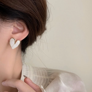 Minimalist gold-edged heart earrings with white marble texture worn by female model