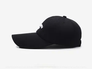 Detail of black cotton baseball cap with white embroidery and long curved visor brim