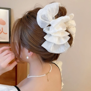 Close-up of a large white layered chiffon bow hair claw clip for a sweet elegant style