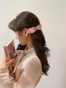 Nahaufnahme einer rosa Schleifen-Haarspange aus Satin an einem Model für einen süßen Look
