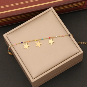 Vue détaillée des breloques d'étoiles dorées et perles émaillées colorées sur le bracelet