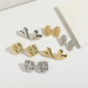 Detail of assorted gold and silver heart-shaped and geometric textured stud earrings