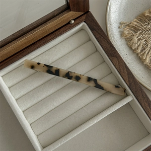 Detailed view of large tortoiseshell acetate shark hair claw clip in wooden jewelry box