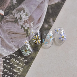 Detail of 3D embossed daisy nail stickers featuring floral patterns on clear press-on nails