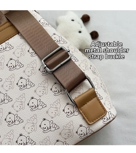 Détail de la boucle métallique réglable et de la bandoulière tressée du sac à motif ours