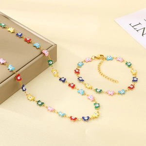 Detailed view of golden necklace and bracelet set with colorful enamel butterfly charms
