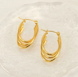 Detail of 18K gold-plated triple-layered oval hoop earrings with sleek metallic finish