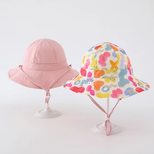 Detail of baby sun hats featuring solid pink and colorful abstract geometric prints