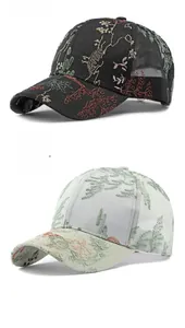 Detail of floral embroidery on mesh baseball caps in black and light green colors