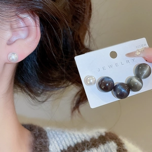 Détail de boucles d'oreilles perles en argent 925 et perles noires sur carte de bijoux
