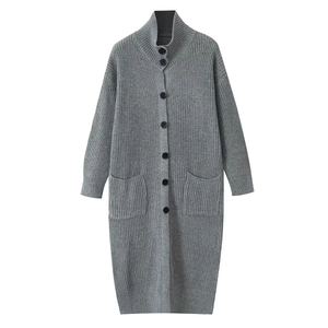 Detail of grey long knit cardigan showing wool-like texture, black buttons, and large pockets