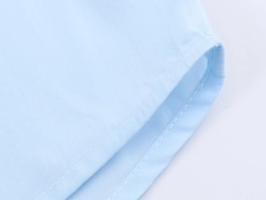 Macro detail of high-quality double stitching and fine texture on a light blue blouse