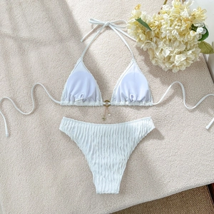 Detail of white textured bikini with gold ring and starfish pearl pendant decoration