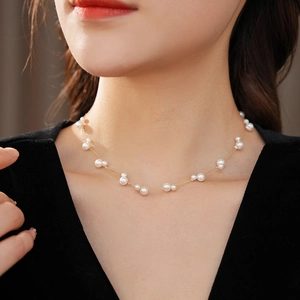 Détail d'un collier de perles élégant à double rangée sur le cou avec chaîne en or