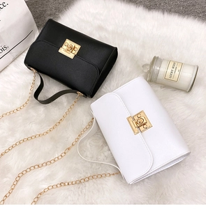 Top view of mini black and white quilted crossbody bags with gold chain on faux fur