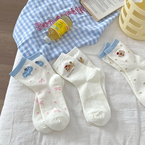 Détail de chaussettes mignonnes en coton avec broderie chien sur fond de tissu blanc