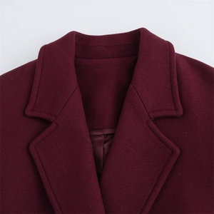 Dettaglio del bavero in lana rosso vino e della trama del tessuto di un cappotto lungo
