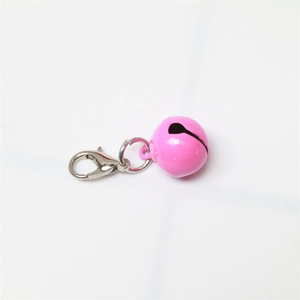 Detailed close-up of a pink metal bell featuring a silver lobster clasp for pet collars