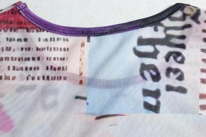 Detail of round neckline and sheer mesh fabric texture with graffiti print