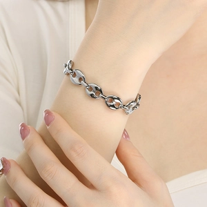 Close-up of silver coffee bean link chain bracelet worn on wrist with polished finish