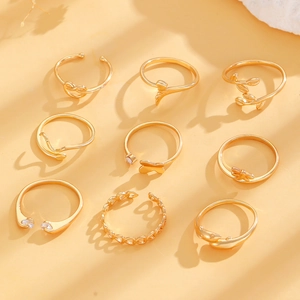 Detailed close-up of 9-piece gold knuckle ring set featuring butterfly and heart patterns
