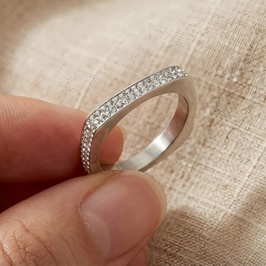 Gros plan d'une bague géométrique en argent sertie de deux rangées de diamants étincelants