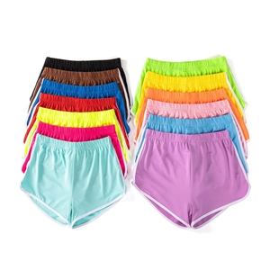 Detailed flat lay of thirteen colorful elastic waist athletic shorts with white piping