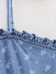 Vista dettagliata dell'abito in denim con motivi a stelle e scollatura con volant