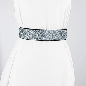 Detail of shimmering blue and white rhinestones on a wide elastic fashion belt