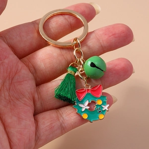 Detail of Christmas wreath keychain with green tassel and gold bell accessory