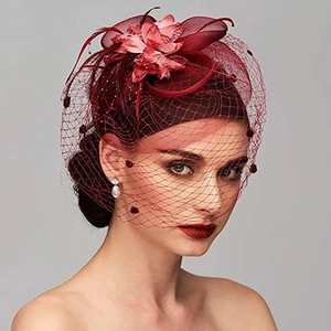 Macro view of red fascinator hat featuring vintage flower, feathers, and delicate face veil