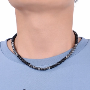 Détail d'un collier de 6mm en pierres naturelles noires mates et grises sur un cou