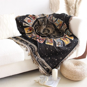 Detail of bohemian tarot woven blanket with fringe on white sofa and boho decor