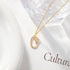 Elegant gold letter necklace with zircon pendant and flower detail on white background