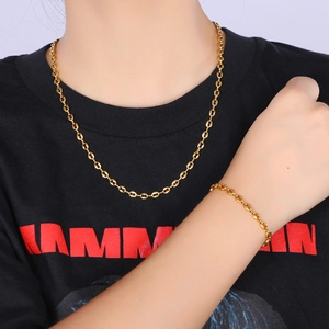 Macro shot of 4.5mm gold coffee bean chain necklace and bracelet on model