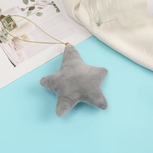Detail of grey plush star keychain with gold cord on a minimalist blue background