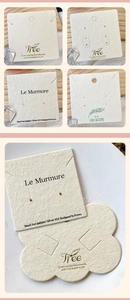 Detailed view of beige textured paper display cards for earrings and necklaces