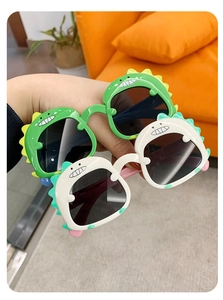 Detail showing high-quality plastic green and white dinosaur sunglasses for kids