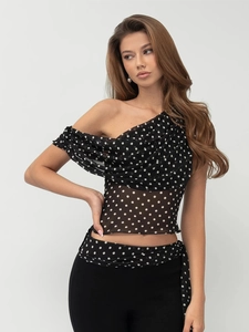 Détail du tissu transparent à pois et du décolleté asymétrique drapé de ce haut à une épaule