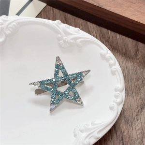 Detailed macro view of a Y2K blue rhinestone star hair clip on a vintage tray
