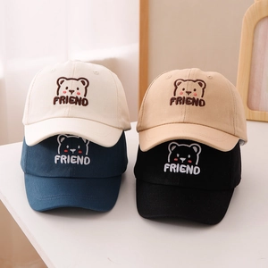 Dettaglio di quattro cappellini per bambini con ricamo orso e scritta FRIEND in 4 colori