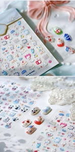 Detalle macro de pegatinas 3D para uñas con diseños de conejitos, corazones y frutas
