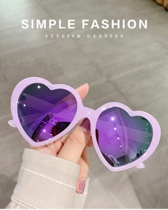 Detail view of stylish purple heart-shaped sunglasses with reflective lenses