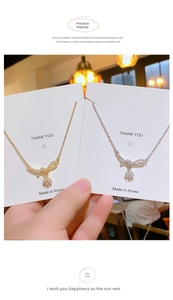 Detailed view of silver and gold bow pendants with sparkling rhinestones on jewelry cards