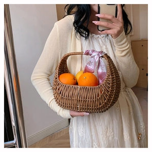 Brown woven rattan basket bag with handle and floral pink silk scarf detail