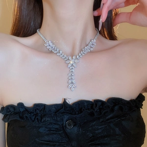 Detail of silver leaf and floral necklace with sparkling zircon pavé on a model neckline